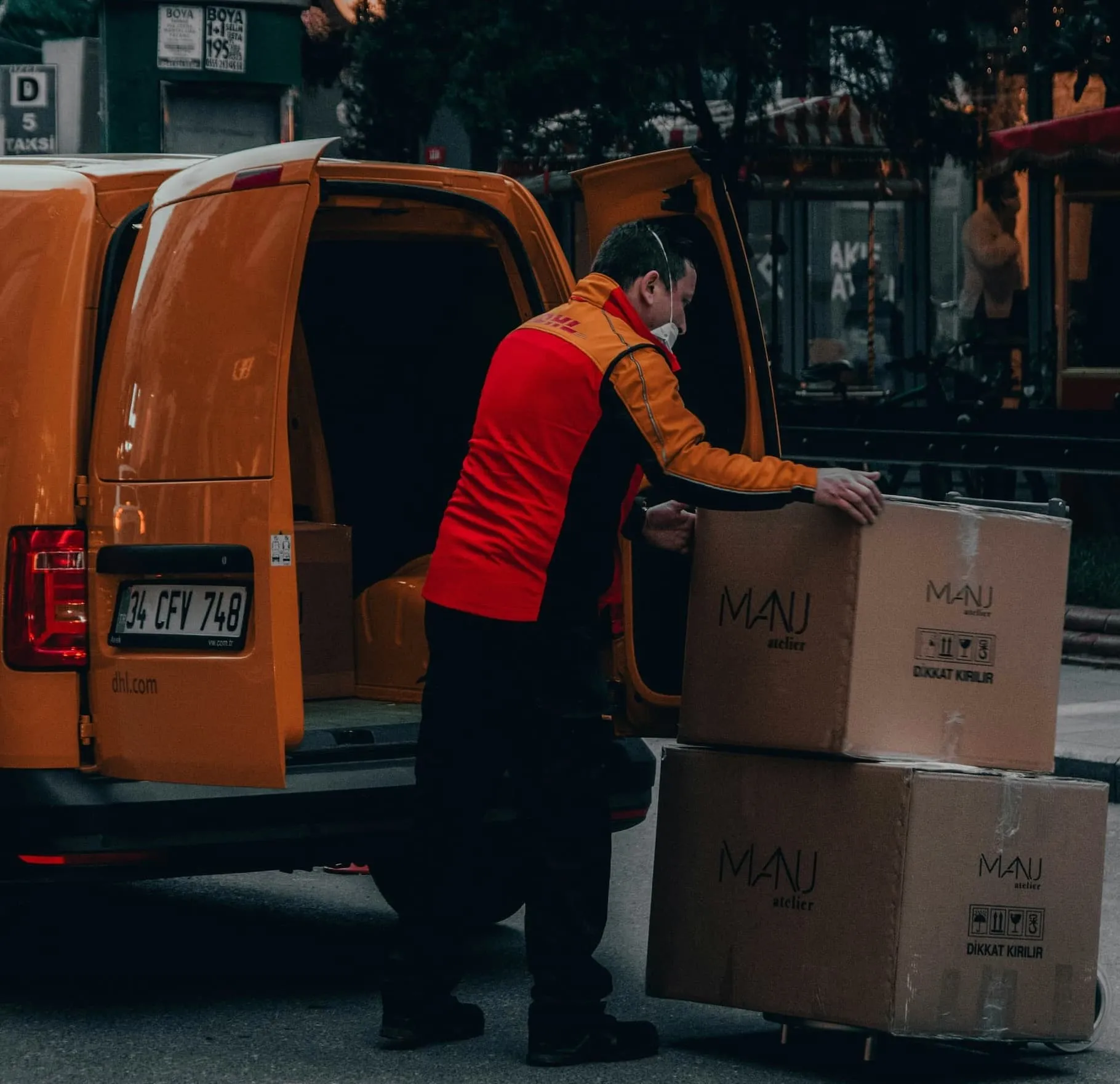 A man unloading boxes from the back of a van.